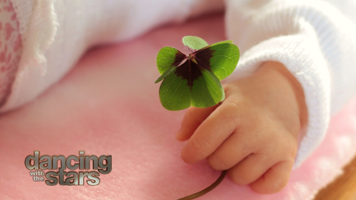A baby holding a 4-leaf clover.