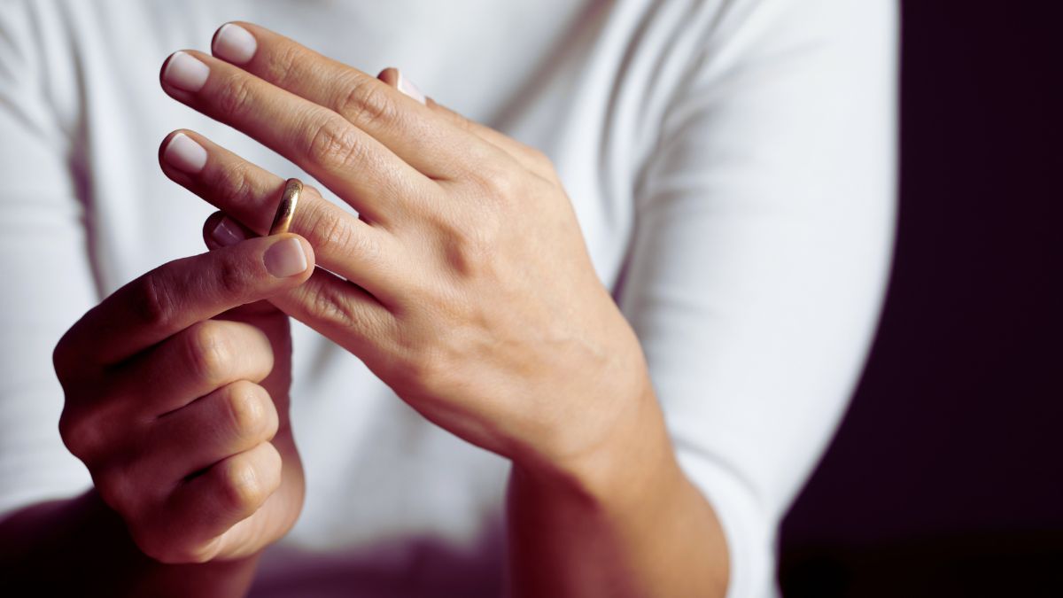 A woman takes off her ring.