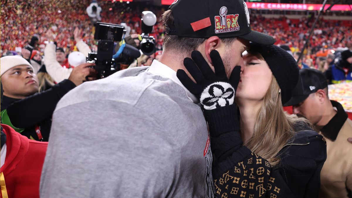 Travis Kelce and Taylor Swift kiss on the field while celebrating his AFC championship win