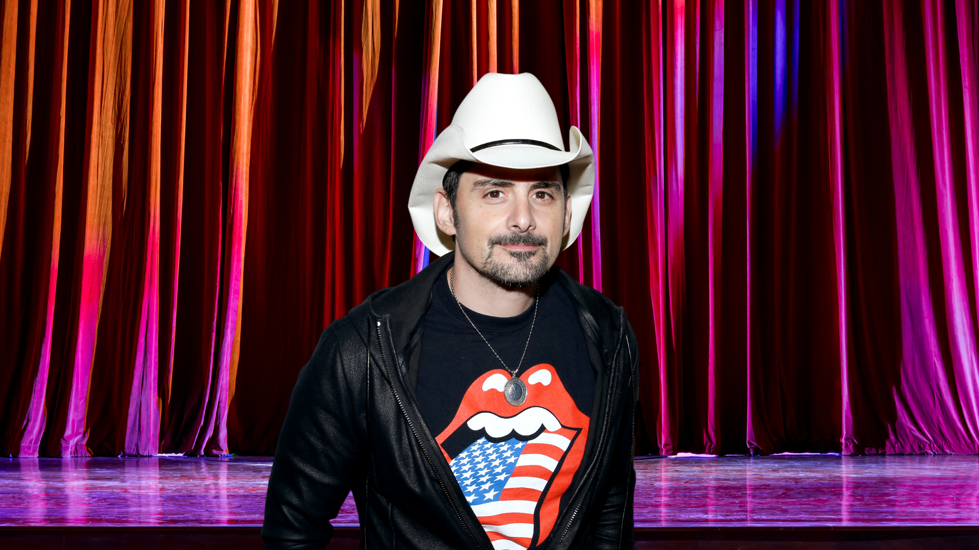 Brad Paisley in front of a stage curtain