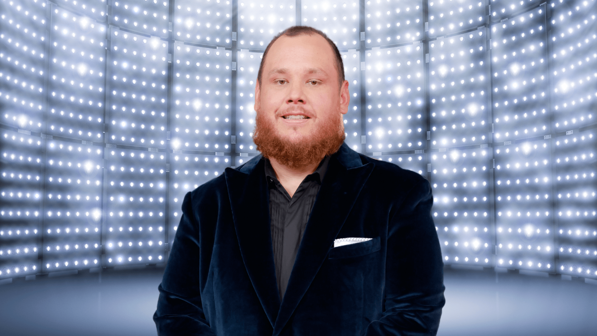 Luke Combs smiling in front of a bright background