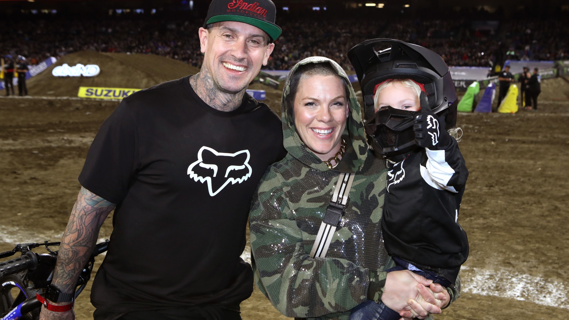 Carey Hart and Pink smiling with their child