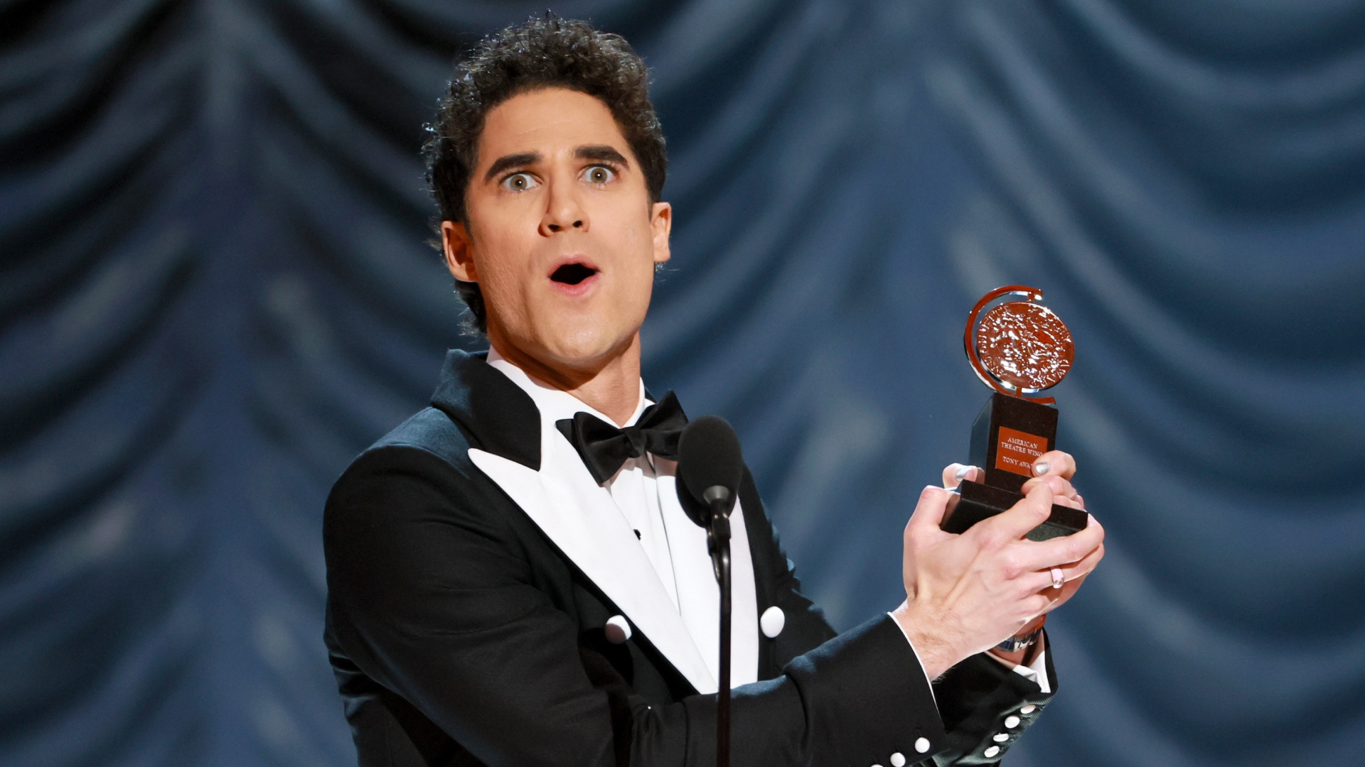 Darren Criss holding Tony Award trophy