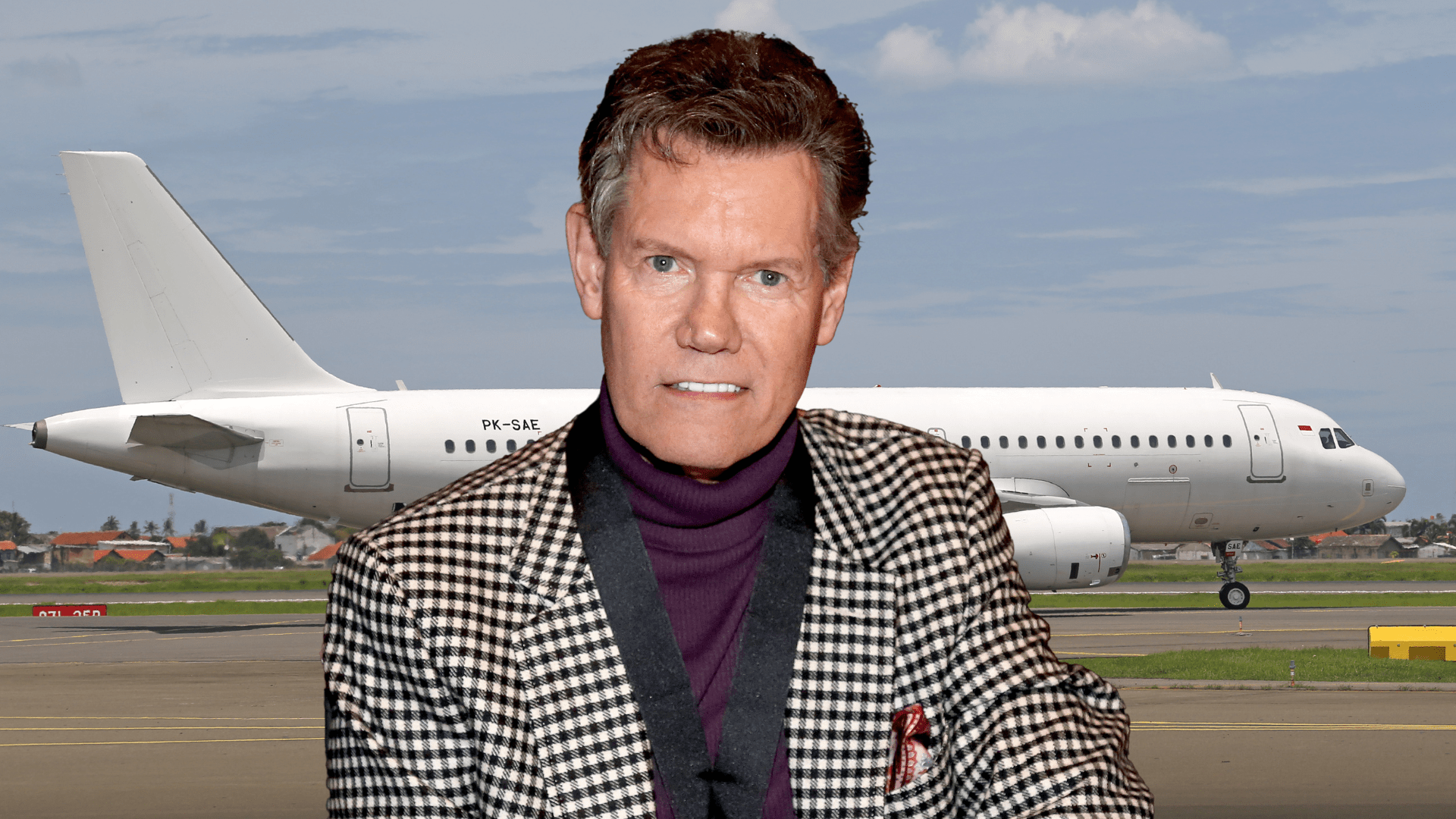 Randy Travis smiling on a tarmac