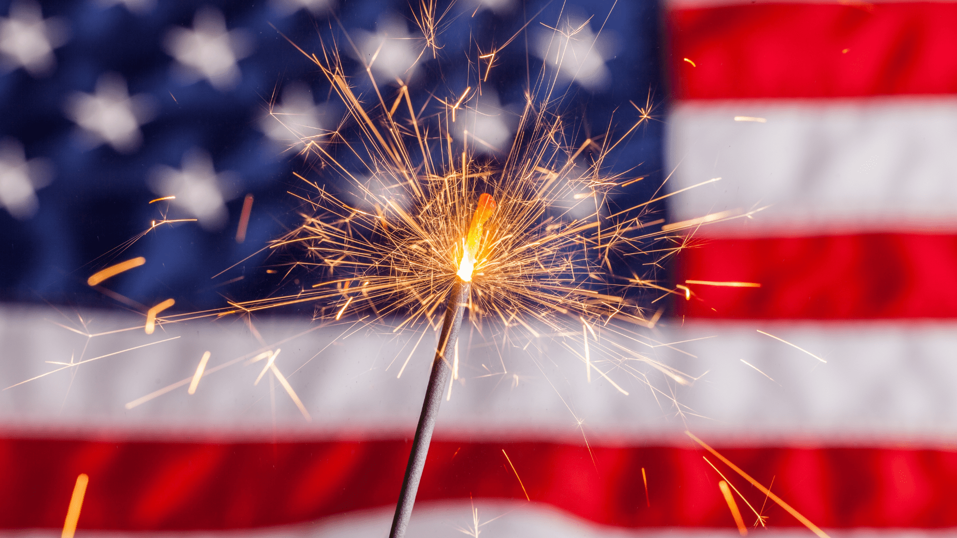 A sparkler in front of an American flag