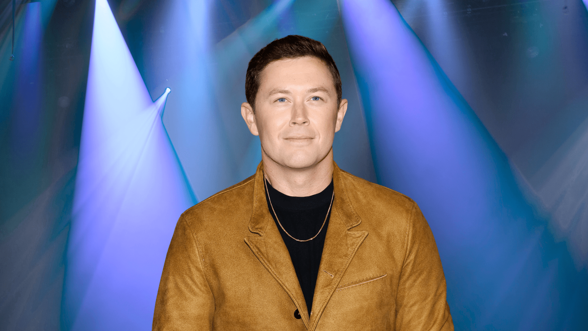 Scotty McCreery posing under blue lights