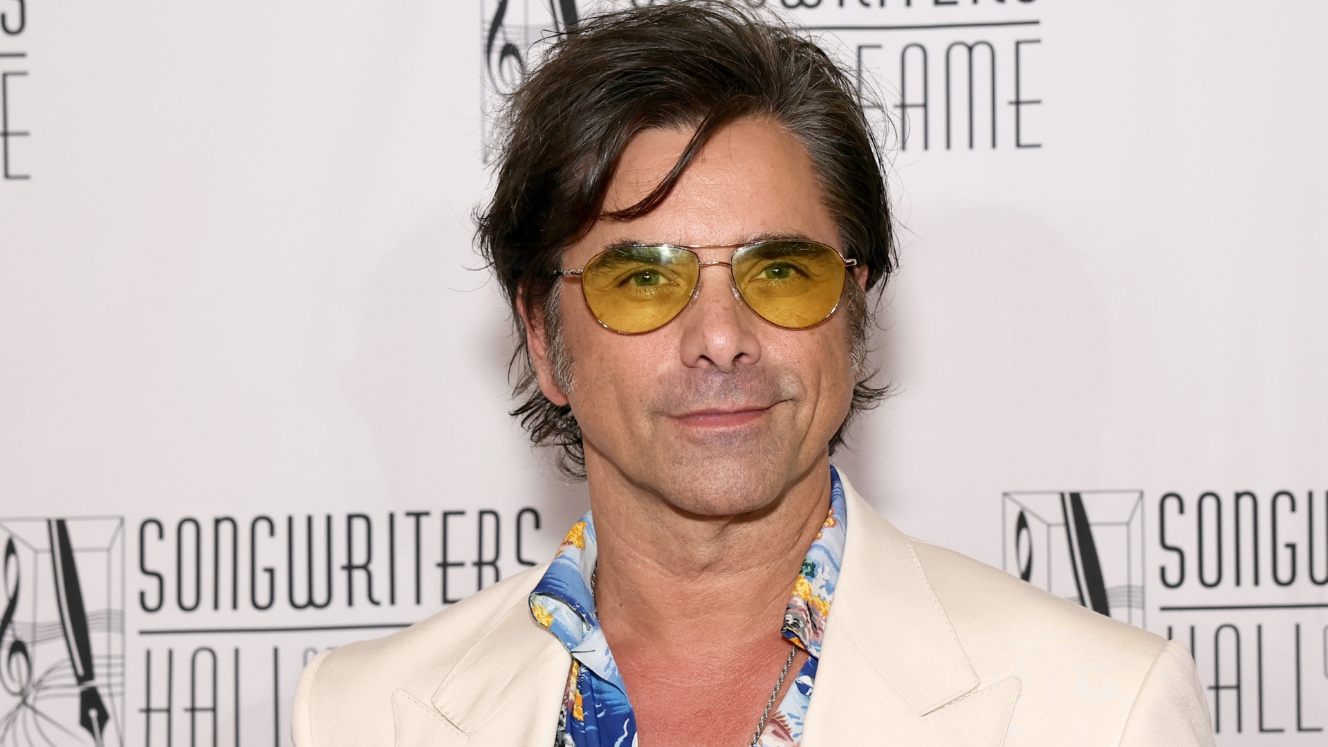 John Stamos wearing yellow sunglasses