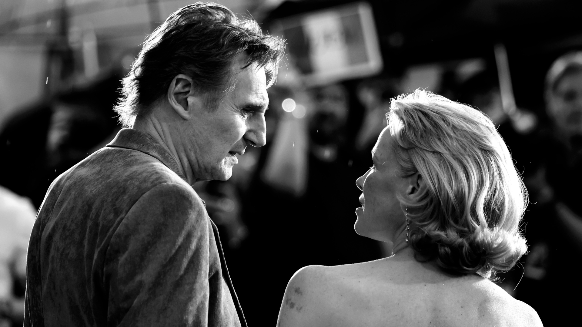 Liam Neeson and Pamela Anderson staring at each other