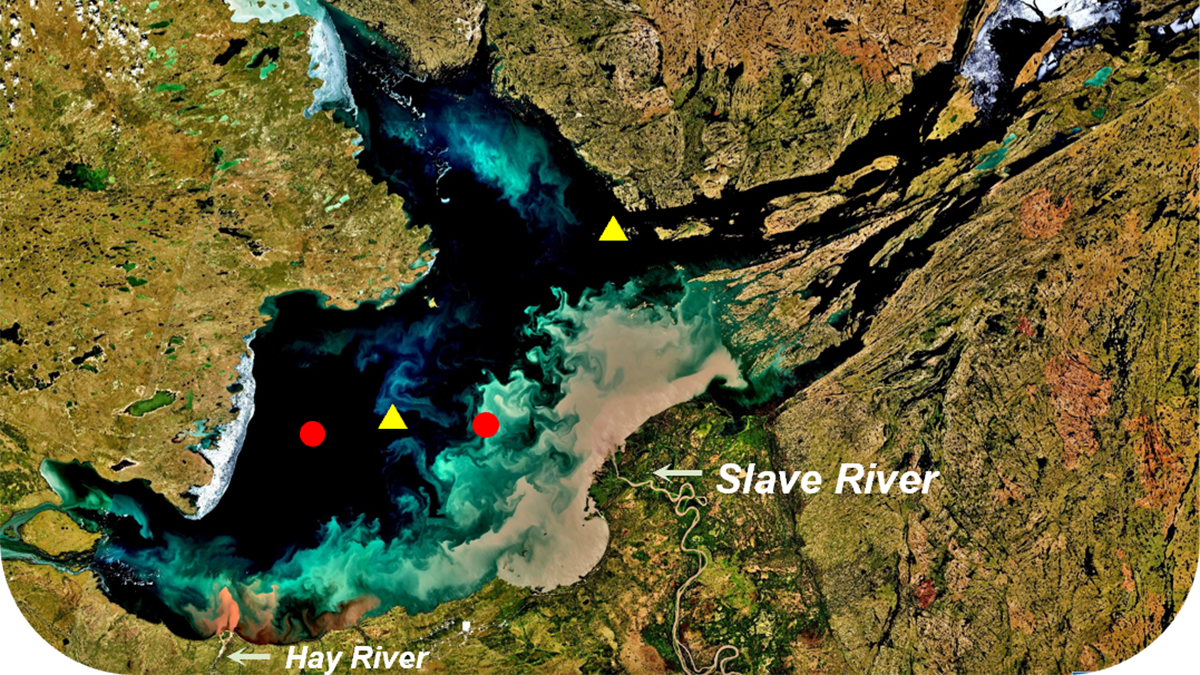 A large, goose-shaped lake stretches across Canada’s Northwest Territories. Two red circles and two yellow triangles mark sites where samples were taken from the lake, and the Slave River and the Hay River are both labeled.