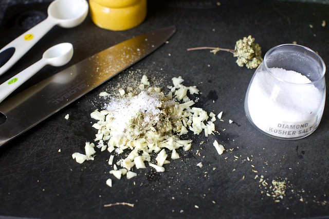 chopping garlic, oregano and salt