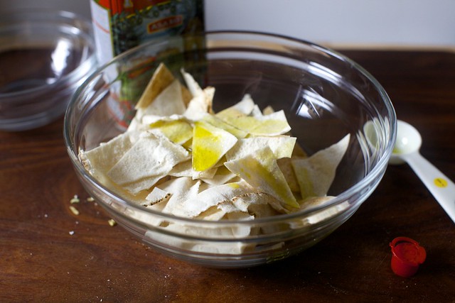 tossing pita with oil to roast into chips