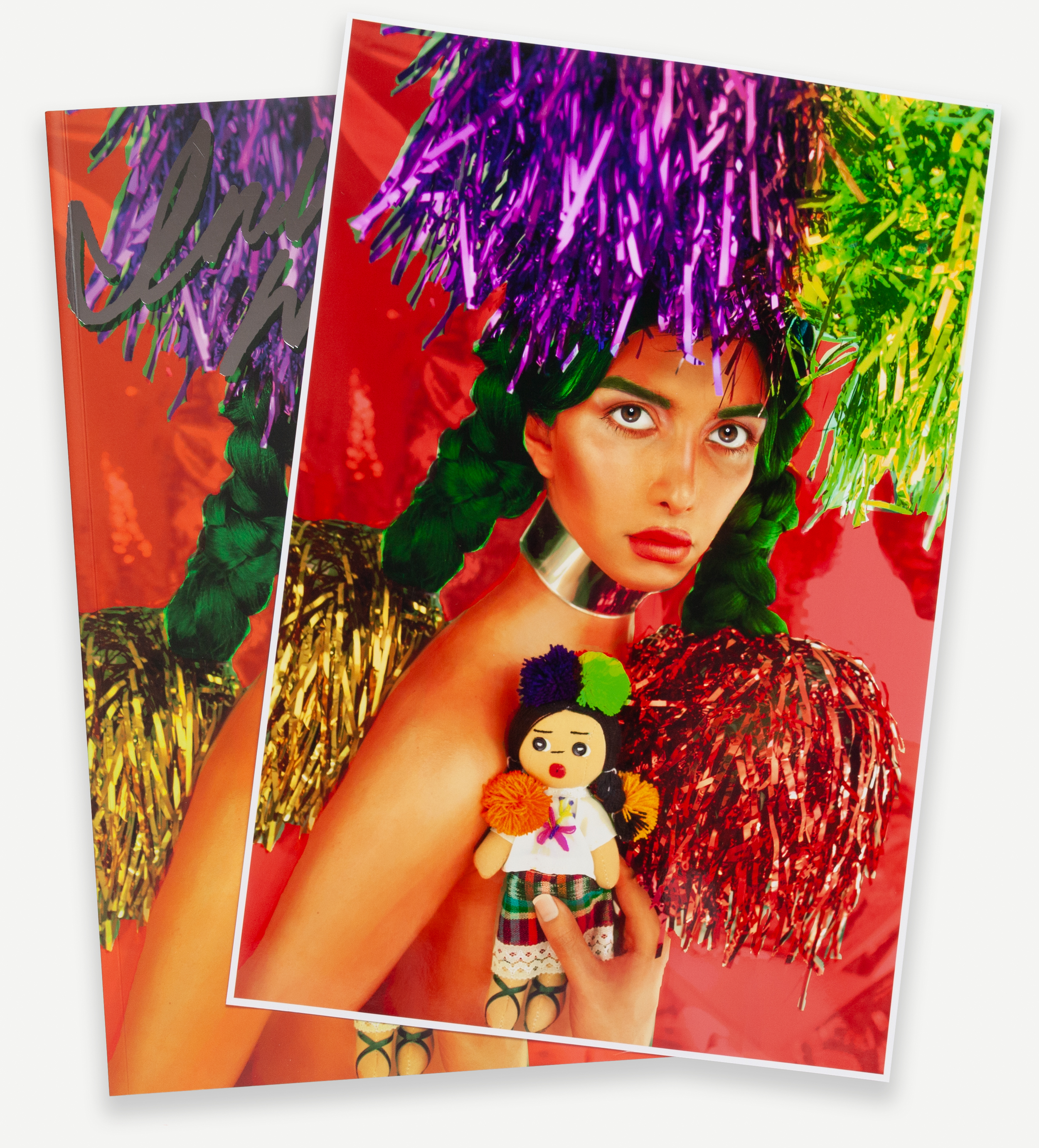 Color print of a woman holding a doll posing under metallic colored pompoms