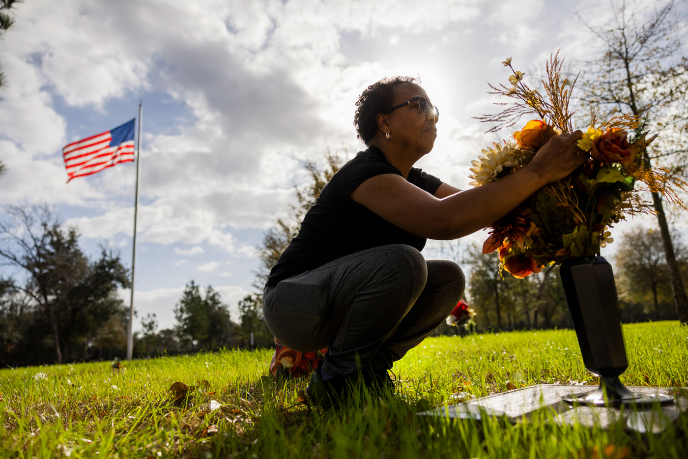 Rowena Ward the replaces flowers on the gravestone belonging to her son, Rory Ward at the cemetery.