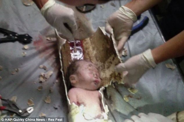 Harrowing: Firefighters work to free the unwanted baby from the pipe in Pujiang, Zhejiang Province, China 