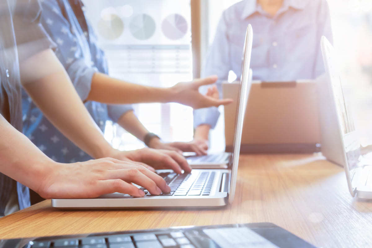 pessoas em reunião: Google Tag Manager pessoas diferentes em um espaço que parece ser de reunião. Todas estão com notebooks e parecem estar discutindo sobre algum assunto