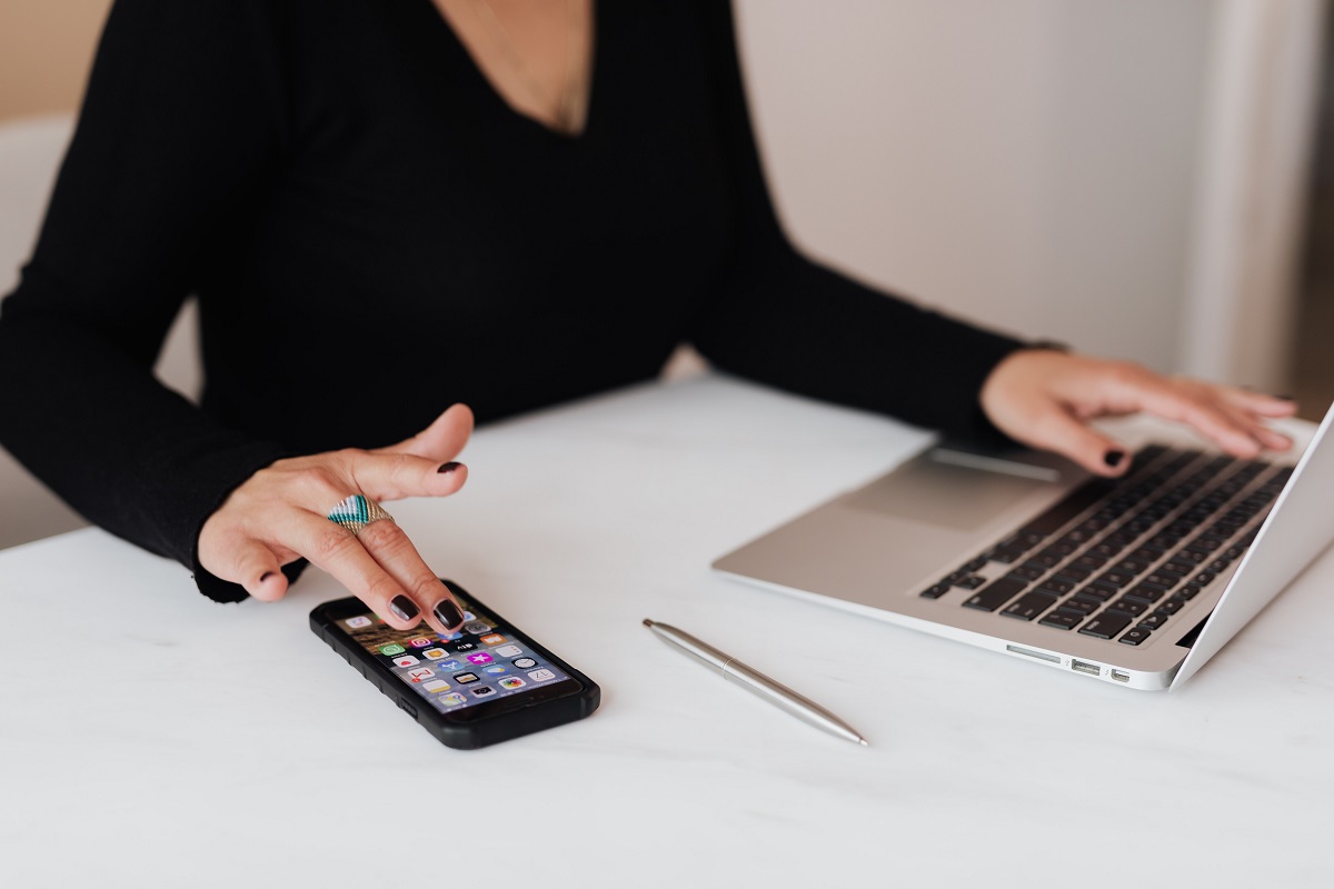 mulher trabalhando no celular e laptop: marketing digital mulher trabalhando sentada em seu laptop e celular, tudo ao mesmo tempo