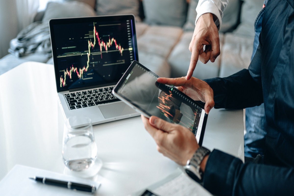 pessoas analisando gráficos: marketing digital imagem de duas pessoas sentadas analisando gráficos em um laptop e um tablet