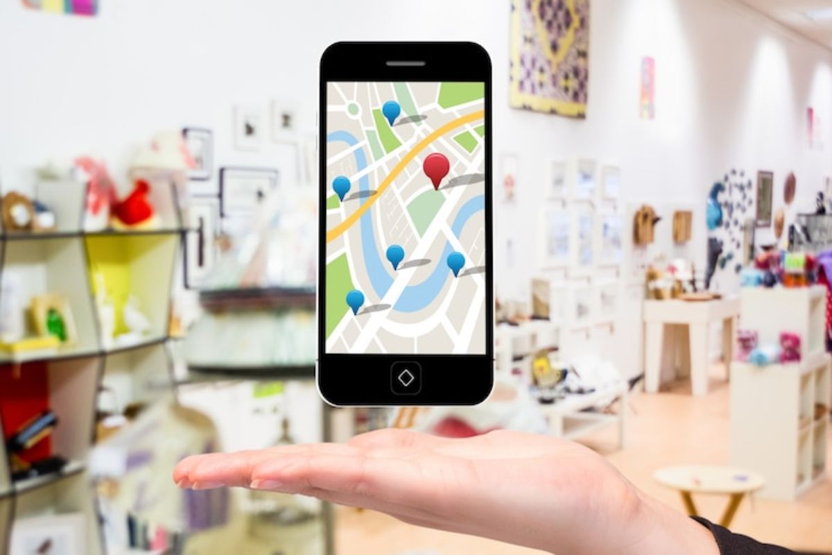 celular com GPS: Google Meu Negócio imagem de uma mão aberta e, em cima dela, há um celular com o GPS aberto
