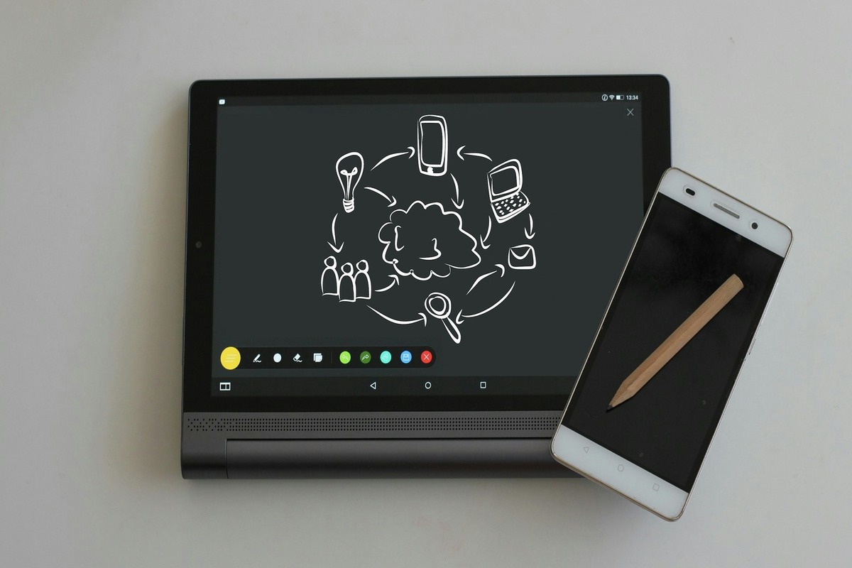 tablet e celular: redes sociais imagem de um tablet mostrando um desenho que representa as redes sociais e, do lado, um celular com um lápis