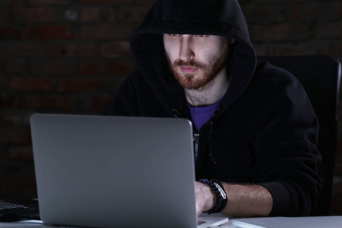 homem de capuz usando laptop: black hat homem de capuz, sentado, usando o laptop