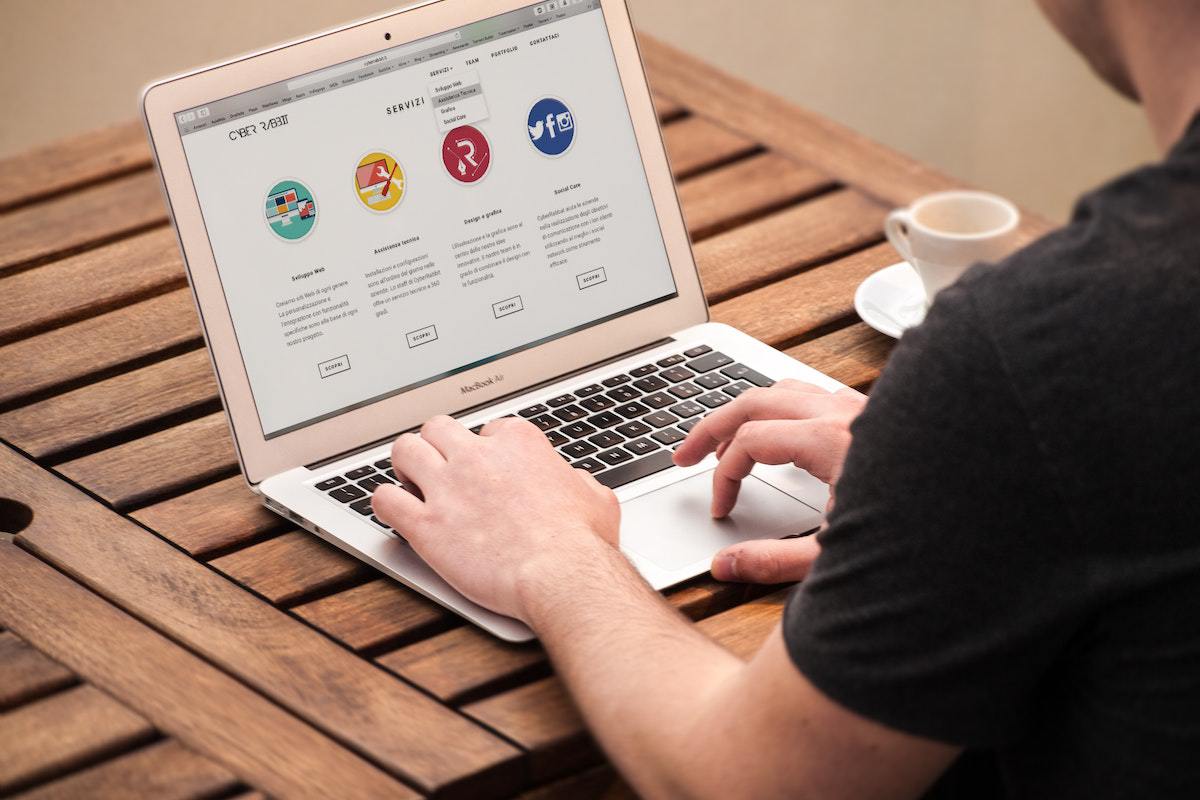 homem trabalhando em seu laptop: brand awareness homem sentado, trabalhando em seu laptop