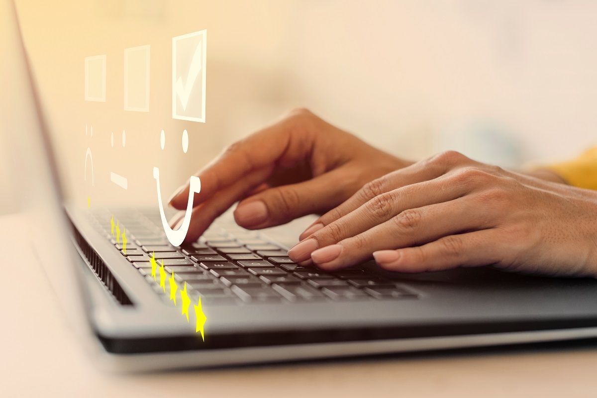 pessoa usando o laptop: experiência do usuário pessoa usando laptop. Na imagem também aparece uma ilustração de uma carinha sorrindo