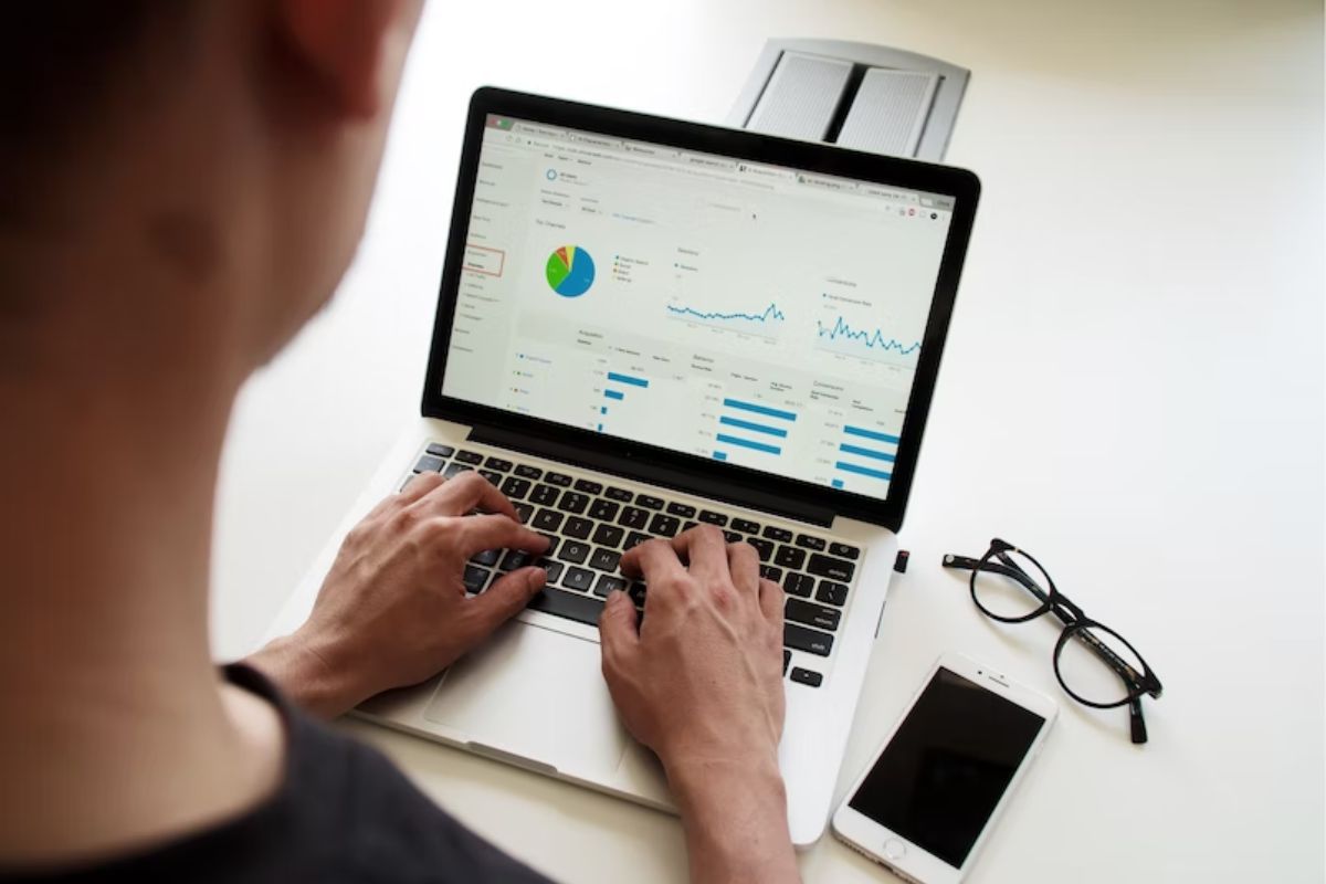 homem trabalhando no laptop: meta description homem sentado trabalhando no notebook, analisando diversos gráficos