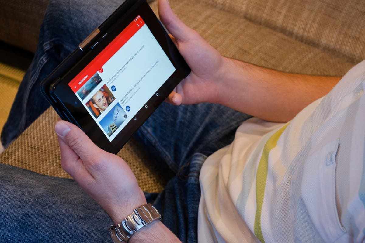 homem usando tablet: Quality Rater Guidelines do Google homem usando o tablet para assistir vídeos