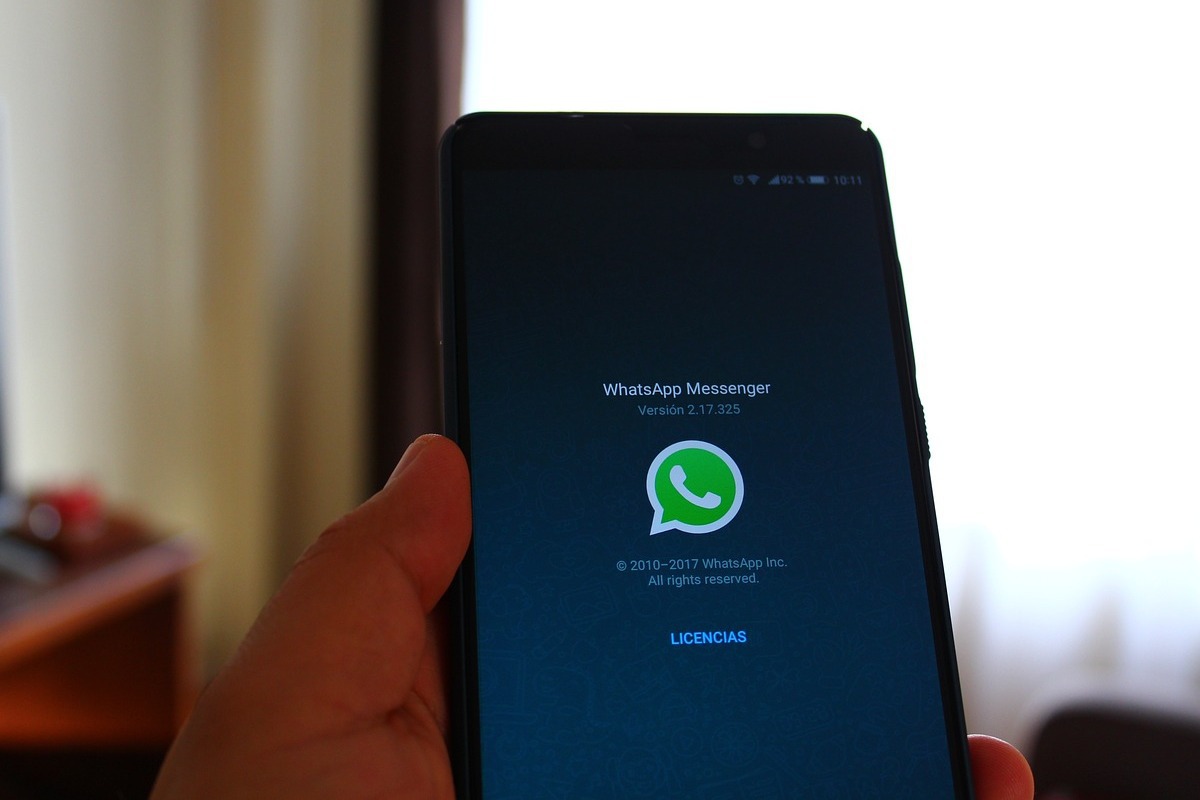 celular com whatsapp: whatsapp business pessoa usando o celular, abrindo o whatsapp