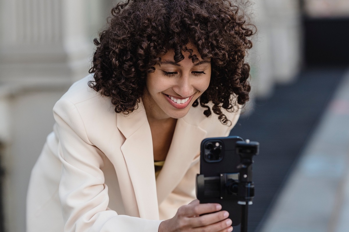 mulher gravando vídeo: conteúdo em vídeo mulher usando o celular em um suporte para gravar um vídeo