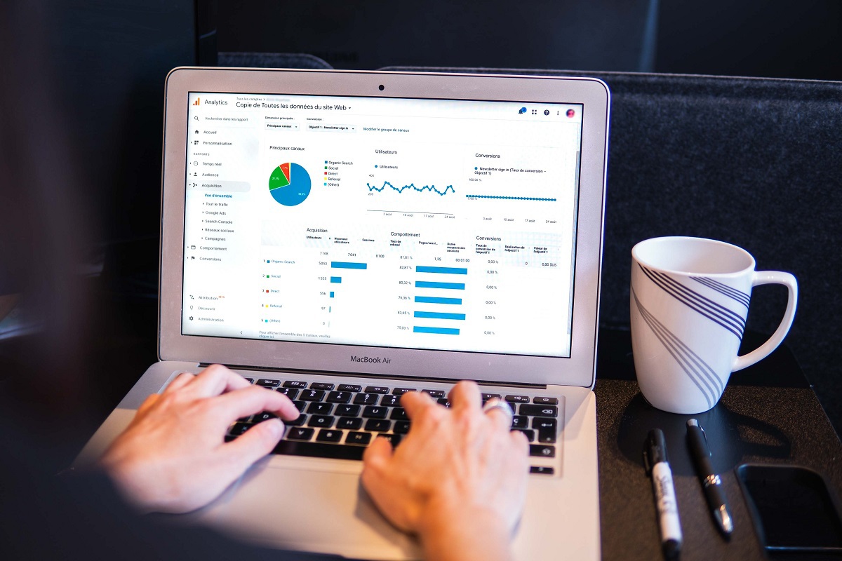 pessoa analisando gráficos: fatores de rankeamento google pessoa sentada, analisando gráficos em seu laptop