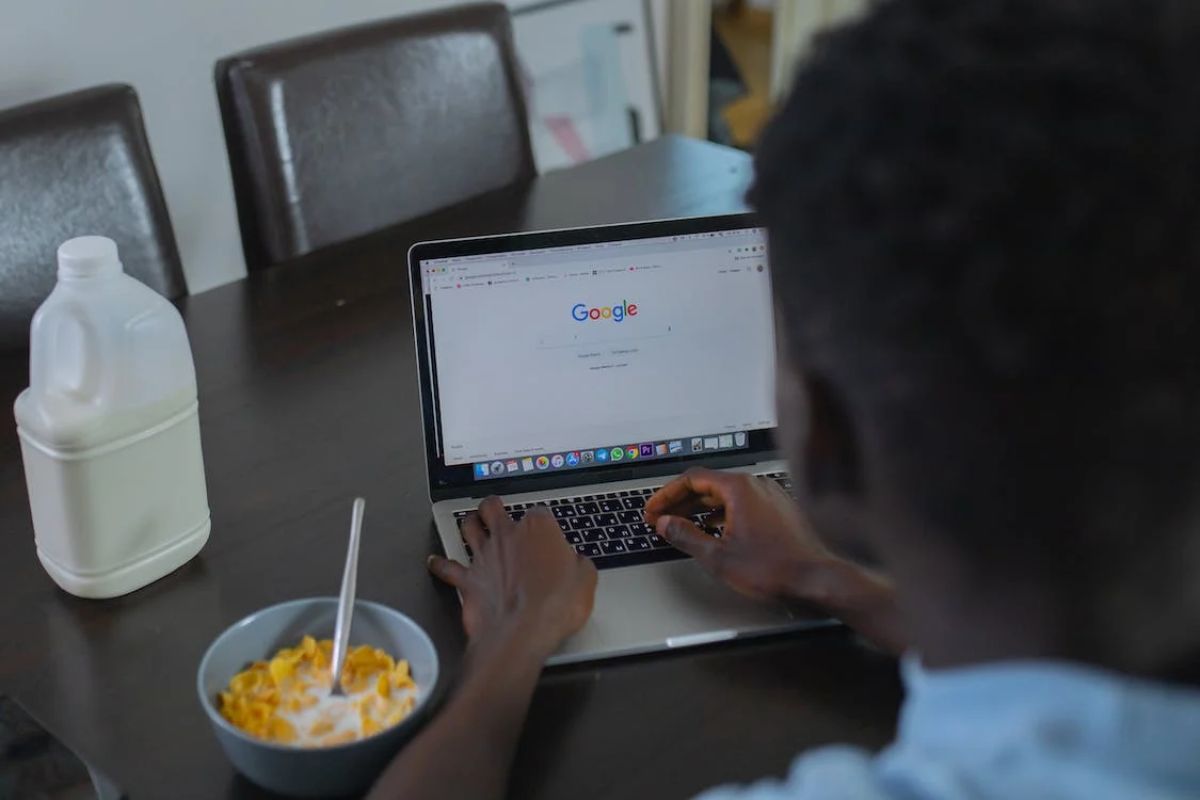 pessoa trabalhando em seu laptop: fatores de rankeamento google homem sentado, trabalhando em seu laptop