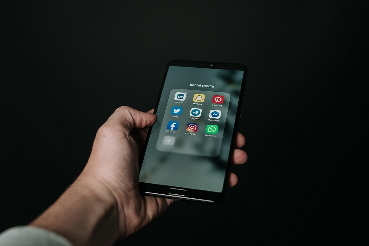 homens usando o celular: história da internet homem segurando o celular