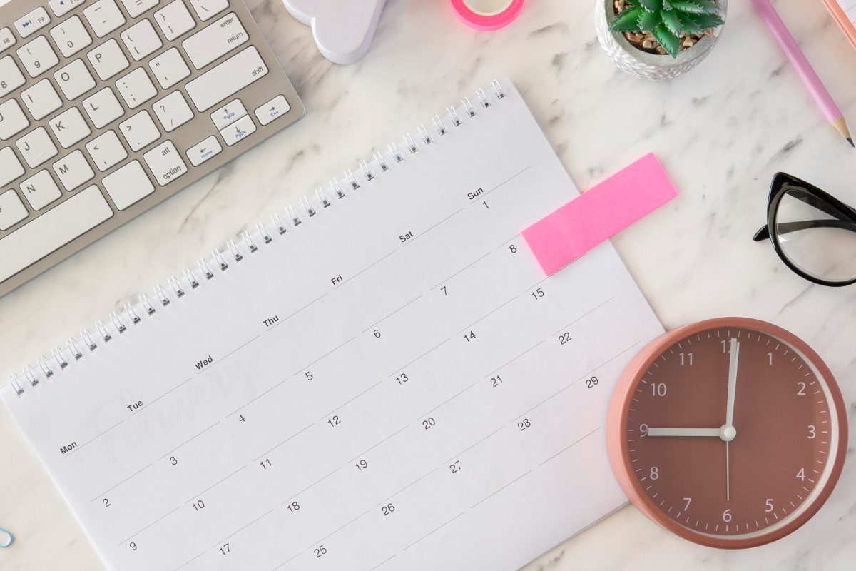 calendário: horário de postagem calendário em cima da mesa, do lado de um relógio e de um teclado