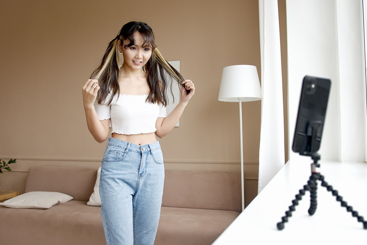 menina gravando vídeo: influenciadores digitais menina gravando vídeo com a ajuda de um suporte e de um celular