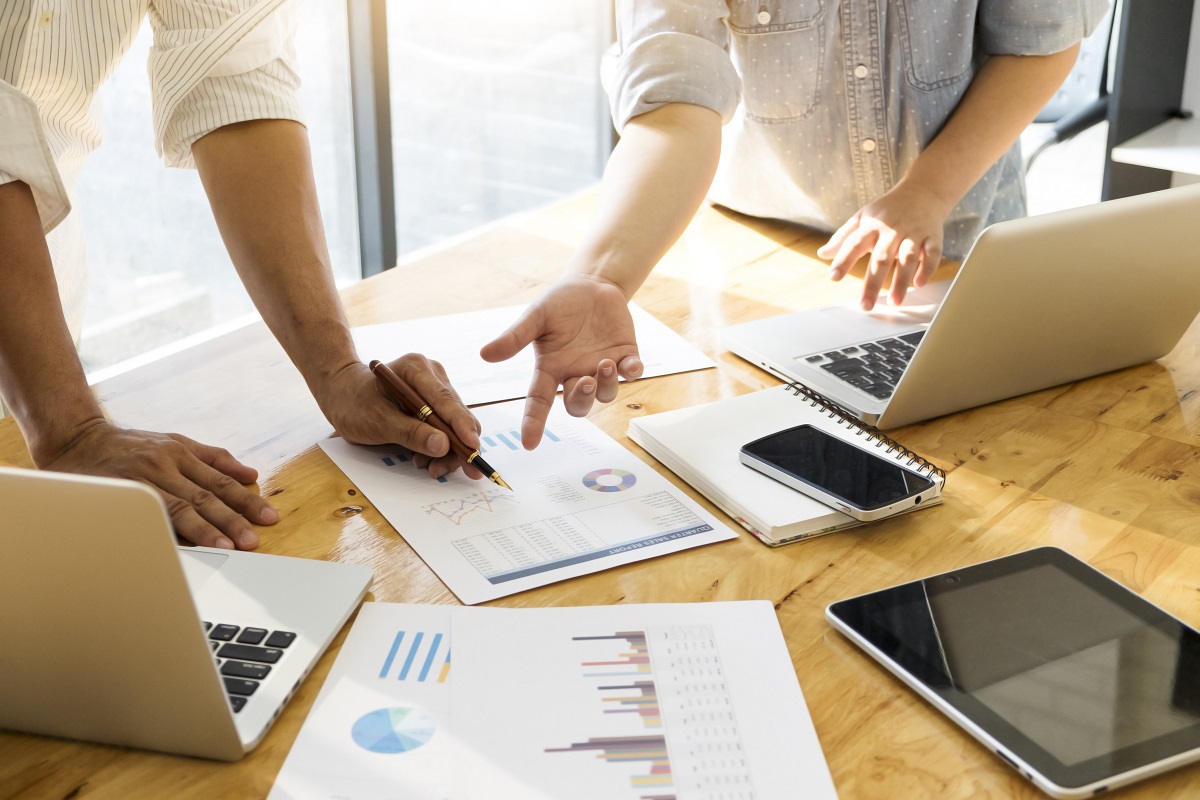 pessoas analisando relatórios: link building pessoas em uma mesa de reunião, analisando relatórios espalhados