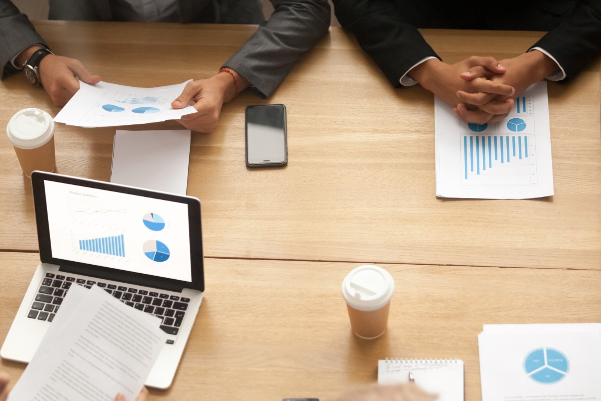 pessoas trabalhando: meta de vendas pessoas sentadas em uma mesa de reunião, trabalhando