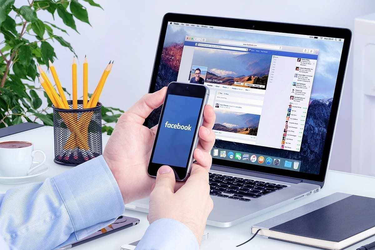pessoa usando celular e laptop: mídias sociais pessoa usando o celular e o laptop ao mesmo tempo