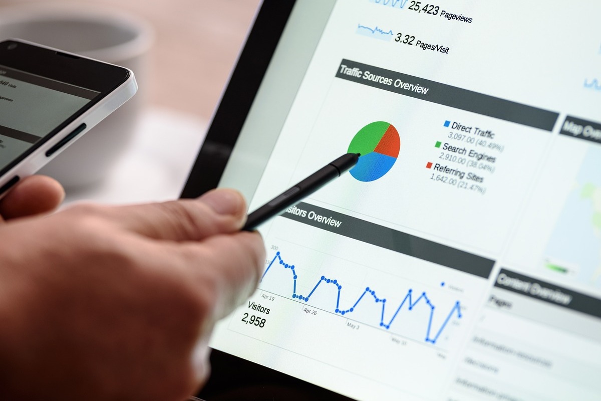 pessoa avaliando gráficos: palavras-chave pessoa usando o tablet e o celular ao mesmo tempo, para avaliar gráficos