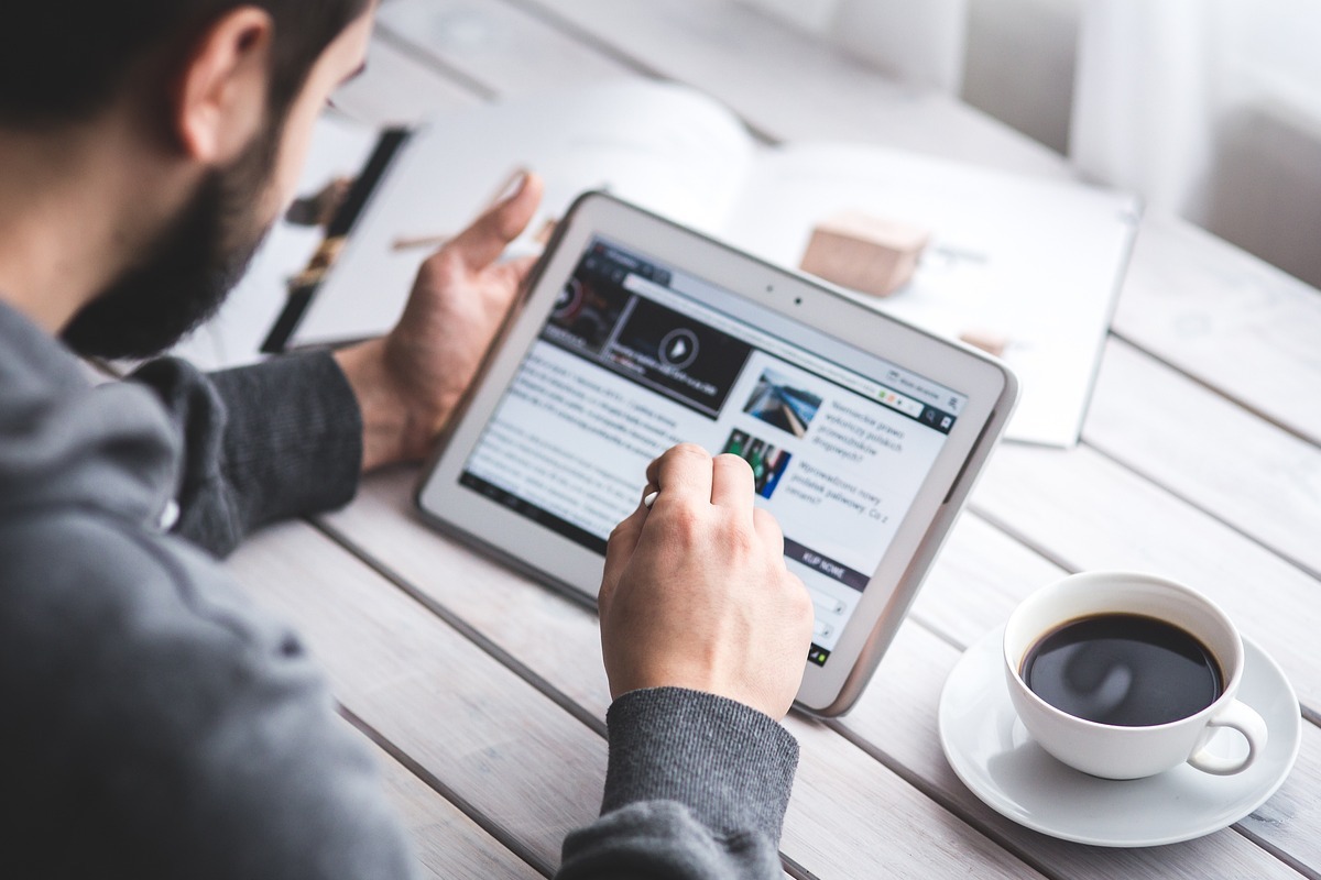 homem usando tablet: penalizações do google homem sentado, usando tablet