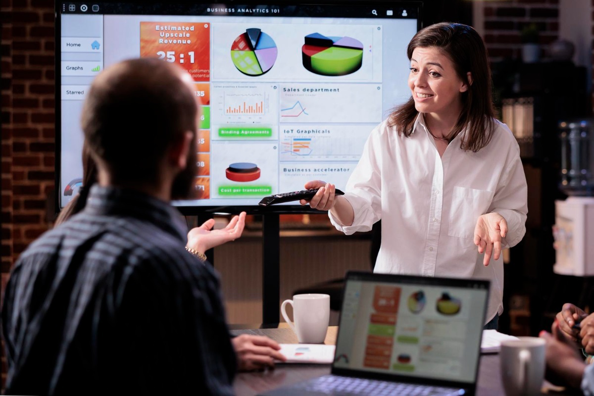 pessoas em reunião: playbook mulher de pé apresentando gráficos para seus colegas de trabalho