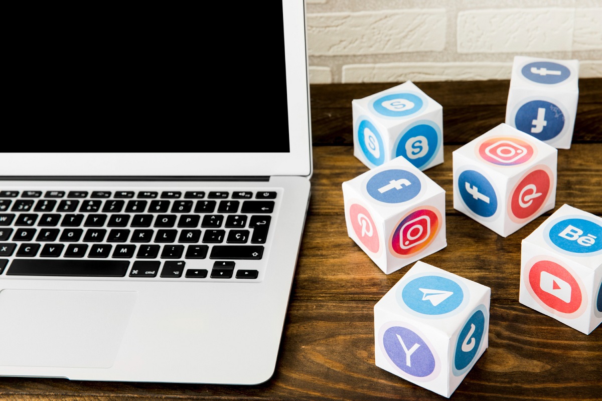 laptop do lado de cubos com vários símbolos de redes sociais
