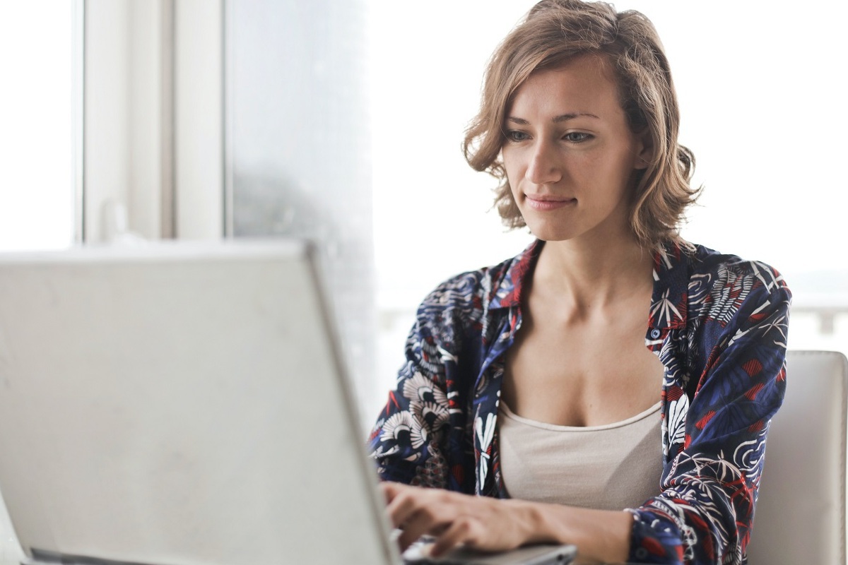 mulher usando o laptop: seo para iniciantes mulher sentada, usando seu laptop