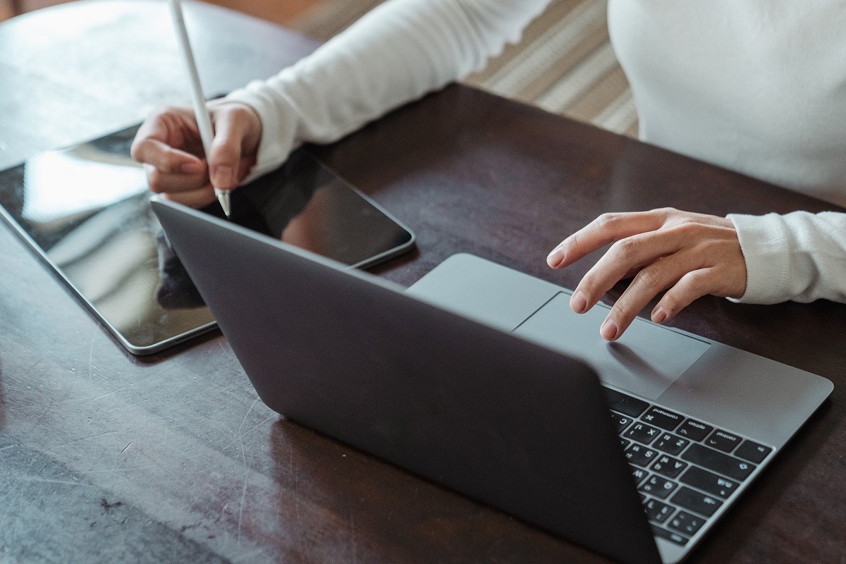 pessoa usando laptop e tablet: twitter ads pessoa sentada, usando laptop e um tablet ao mesmo tempo