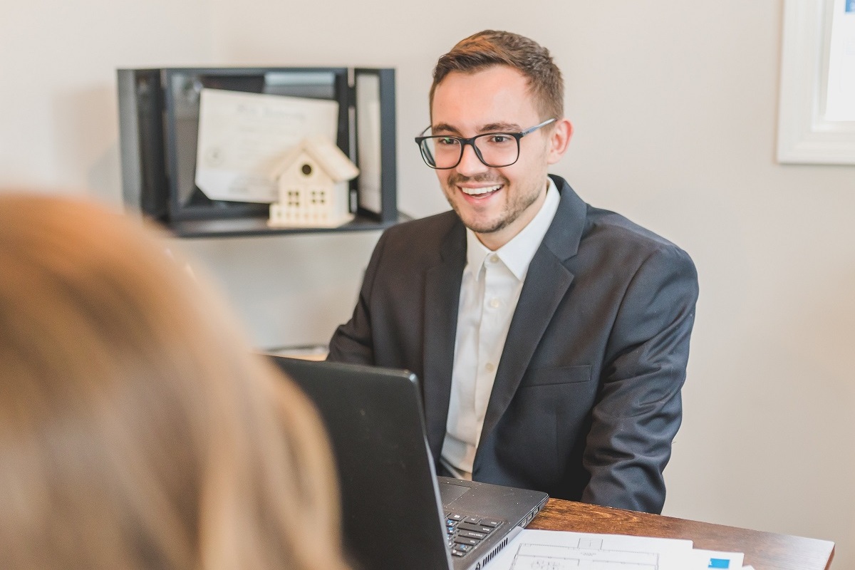 pessoas conversando: vendas complexas homem sentado, sorrindo e conversando com outra pessoa
