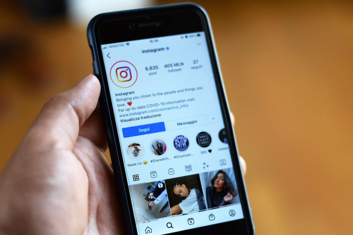 Pessoa com smartphone: agendamento de posts no Instagram Pessoa usando Instagram em smartphone