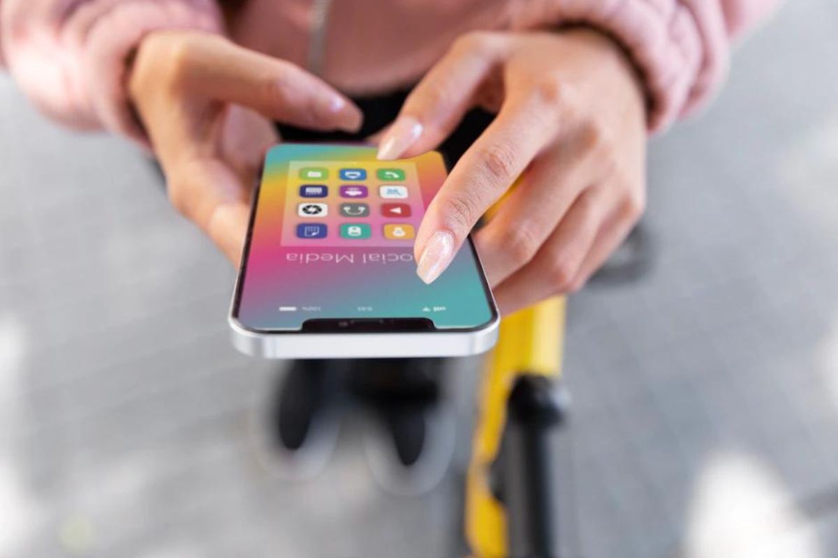 iPhone na mão: aplicativos de marketing Mulher com unhas grandes segura iPhone que está aberto no seu menu de aplicativos