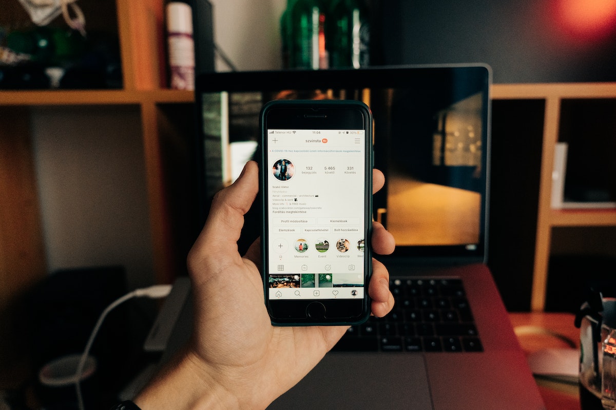 homem segurando o celular com a tela do Instagram aberta