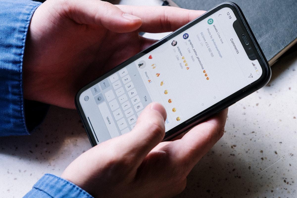 Redes sociais: conteúdo gerado por usuário Pessoa com celular comentando em post nas redes sociais