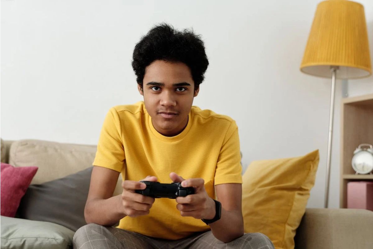 garoto focado com um controle de videogame nas mãos